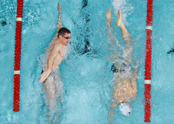 Two swimmers pass each other during lap swim.